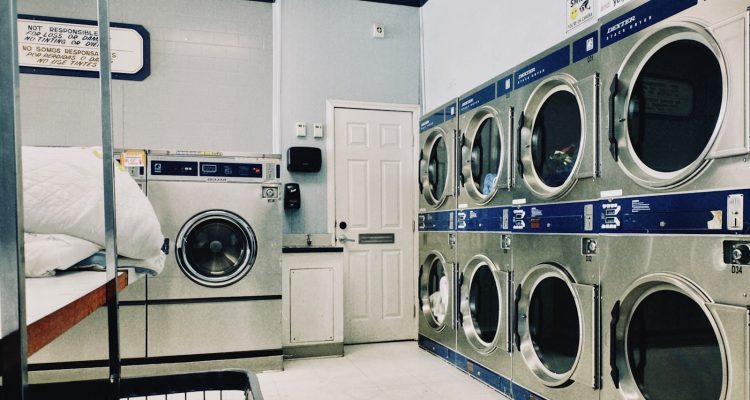 a row of washers and dryers in a laundry room